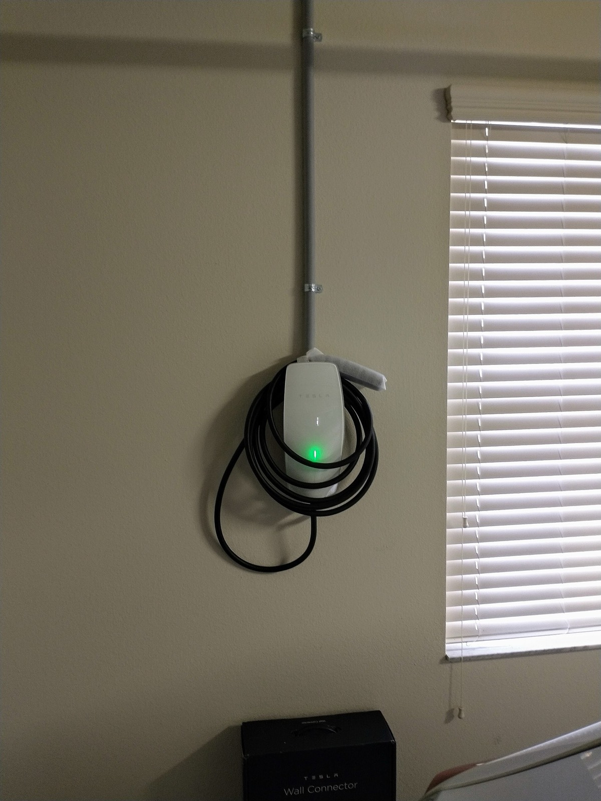 Tesla Wall Connector installed on a garage wall